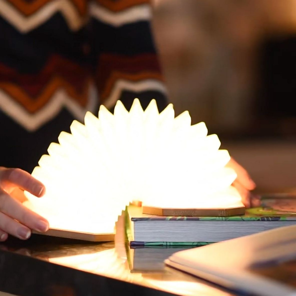 Gingko Smart Accordion Lamp over edge of book