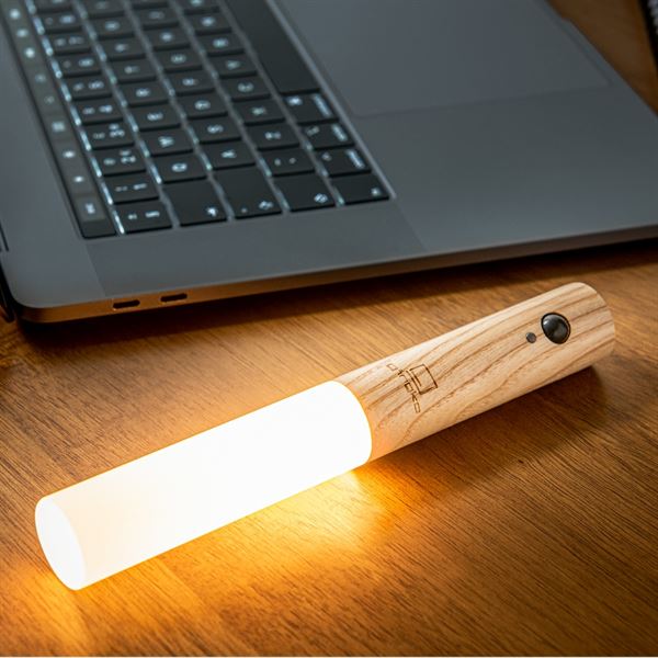 Gingko smart baton wall light - white ash turned on next to laptop