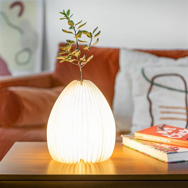 Smart Vase Light lit in lounge with white flowers against orange softa